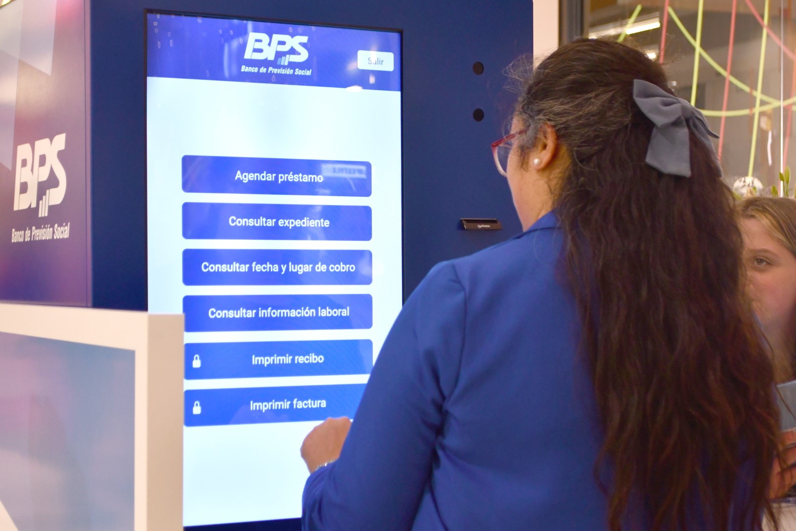 Mujer usando la pantalla de autogestión